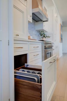 an open drawer in the middle of a kitchen