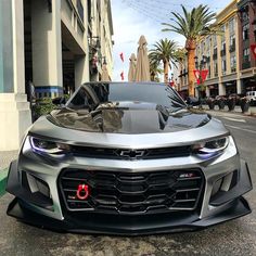 a silver sports car is parked on the street