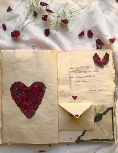 an open book with paper hearts and flowers on the pages, next to it is a poem written in cursive writing