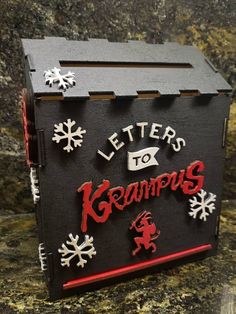 a black box with red lettering and snowflakes on the side that says letters to krampus