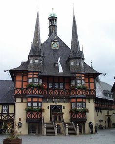 an old building with many windows and steeples on the top floor is decorated with flowers