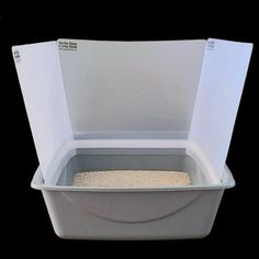 a white plastic container filled with sand on top of a black background and the lid is open