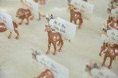 small deer figurines with place cards on them