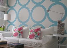 a living room with white couches and blue circles on the wall behind them,