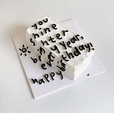 a piece of cake with writing on it sitting on top of a white paper sheet