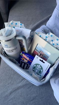 an open suitcase filled with personal items on top of a bed in someone's lap