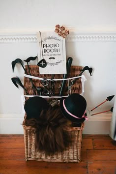 a woman laying on top of a basket with lots of hats hanging from it's sides