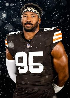 a football player wearing an orange and white uniform is posing for a photo in the snow