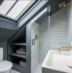 a white toilet sitting next to a bathroom sink under a skylight in a bathroom