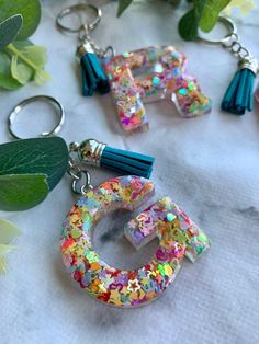 the letters are made out of plastic beads and tasseled with colorful sequins