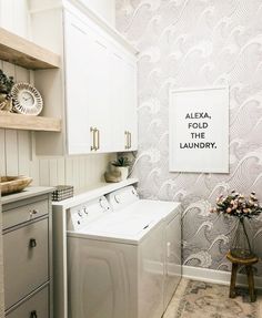 a washer and dryer sitting in a room next to a wallpapered wall