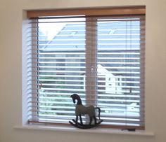 a toy horse sitting on top of a window sill