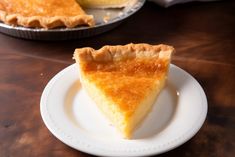 a piece of pie sitting on top of a white plate next to a metal pan