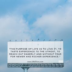 a billboard with a quote on it in front of a blue sky and white clouds