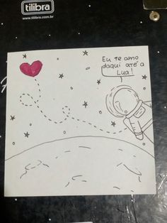 a piece of paper with a drawing of an astronaut holding a red heart on it