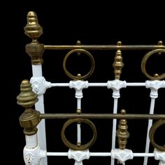 an ornate gold and white metal bed frame