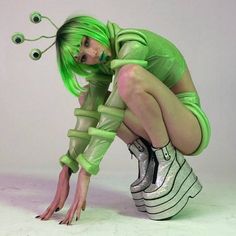 a woman with green hair is bent over and holding her shoelaces up to her face