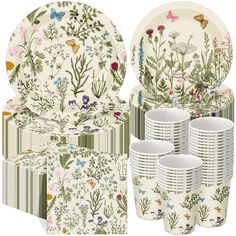 a set of dinnerware with flowers and butterflies on it, including plates, napkins, cups, and bowls