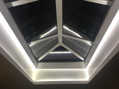 the ceiling is lit up with white lights and black glass panels on it's sides