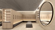 an empty locker room with benches and mirrors on the wall, along with shelves filled with shoes