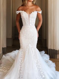 a woman in a white wedding dress posing for the camera with her hands on her hips