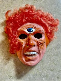 Vintage Cyclops With Orange Hair Halloween Mask - Vintage Halloween - Halloween Decor - 1986 USA C F Mfg Co - Ben Cooper Mask - Halloween Costume These vintage masks are great for props at your Halloween party and sure are conservation pieces for those of us who love Halloween! Great condition/rare to find this nice! - Mask Measures: 9 inches by 6.3/4 inches Embossed mark on the bottom:  "1986 C. F. Mfg. Co USA" sticker on interior, rubber band missing/no cracks This lot is one of those great pieces of nostalgia that sweetly reminds us of wonderful days and memories gone by... Thank you for stopping by for a peek and please visit my Etsy shop where you will find lots of vintage goodies to bring YOUR great memories back! Additional photos are available upon request. Please convo VintageFarm Vintage Halloween Carnival Masks And Prosthetics, Old Halloween Masks, Retro Halloween Mask, Vintage Halloween Masks Retro, Vintage Halloween Masks Paper Mache, New Children's Books, Vintage Farm, Orange Hair, Halloween Masks