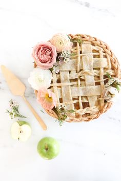 an apple pie on a table with flowers