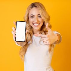 a woman holding up her cell phone and giving the thumbs up sign with both hands