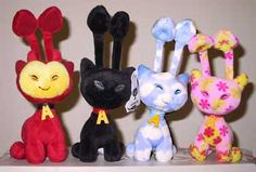 four stuffed animals are lined up on a shelf