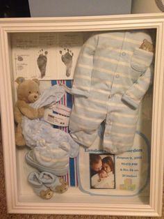 a baby's gift set in a white frame with blue and white striped onesie