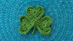 a green crocheted shamrock sitting on top of a blue table