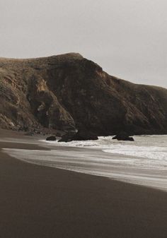 two people walking on the beach with surfboards