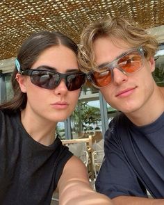 a man and woman taking a selfie in front of a restaurant