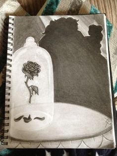 a drawing of a bottle with a rose in it sitting on a bed next to a pillow