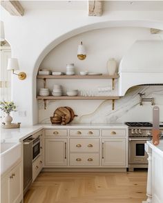 a kitchen with white cabinets and marble counter tops