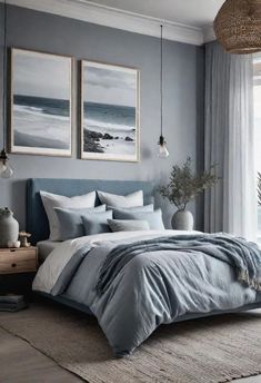 a bedroom with grey walls and blue bedding, two pictures on the wall above the bed