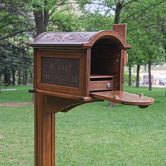 a wooden mailbox sitting in the middle of a park