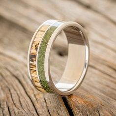 a wedding ring with wood and moss inlays on the inside, sitting on a wooden surface