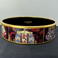 Beautiful Hermes Wide Bangle In "Coin Purse" Printed Enamel With Gold-Plated Hardware. Limited Edition Collectors Item! It Has Never Been Worn, Other Than To Try On, And Is In Excellent Condition. Made In France. This Item, In Its Particular Pattern And Color, Has Been Discontinued And It Would Be Difficult To Source Elsewhere. I Am Selling This For My Mom And I Did Some Basic Measurements On Her To See Who This Would Fit. My Best Estimate Is That This Is A Hermes Size 65 (Medium). It Fits Very Snugly Past My Mom’s 8 Inch Circumference Hand And Dangles Relatively Loosely On Her 6.25 Inch Wrist. I’d Say There’s About A Quarter To A Half-Inch Of Space Between Her Wrist And The Inner Dia Hermes Bangle, Hermes Jewelry, Coin Bracelet, For My Mom, Try On, Gold Plating, Bangle Bracelet, Womens Jewelry Bracelets, Bangle Bracelets