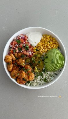 a white bowl filled with rice, beans, avocado and other food items