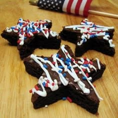 four brownies with white and red sprinkles are on a table next to an american flag