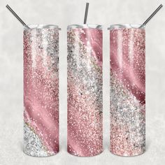 two pink and silver glitter tumblers with straws in them on a white background