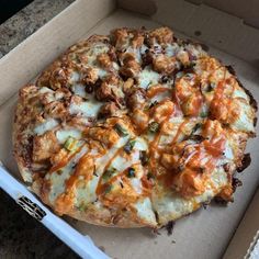 a pizza sitting inside of a box on top of a counter next to a spatula