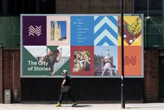 a man walking down the street in front of a large advertisement on a building wall