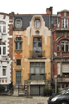 a car parked in front of an old building with many windows and balconies