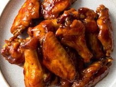 some chicken wings are on a plate and ready to be eaten by the person in the photo