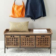 two purses hanging on the wall next to a wooden bench with baskets underneath it