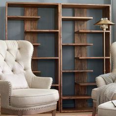 a living room with two chairs and a bookcase on the wall next to each other