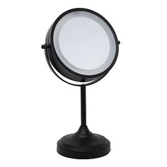 a round mirror sitting on top of a black stand