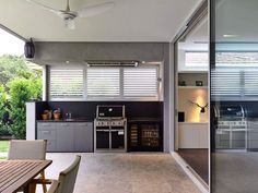 an outdoor kitchen and dining area with sliding glass doors